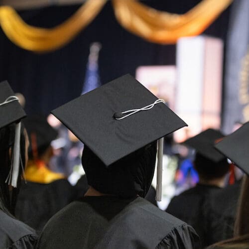 PNW graduates during a commencement ceremony. The graduates are pictured from the back