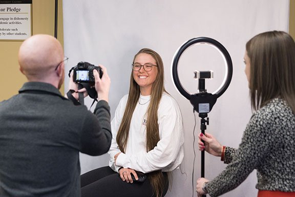 A student takes a headshot photo in the Career Center