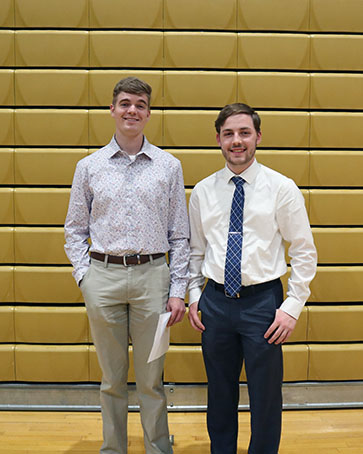 Two students in professional attire stand together