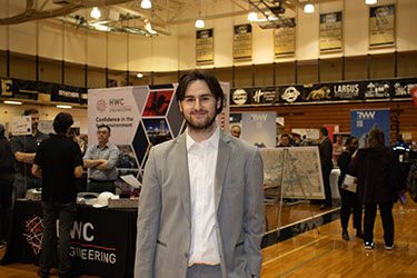A student in a suit poses during a career expo