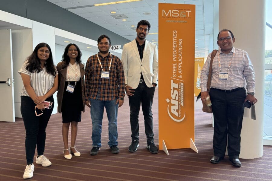 group standing with conference banner