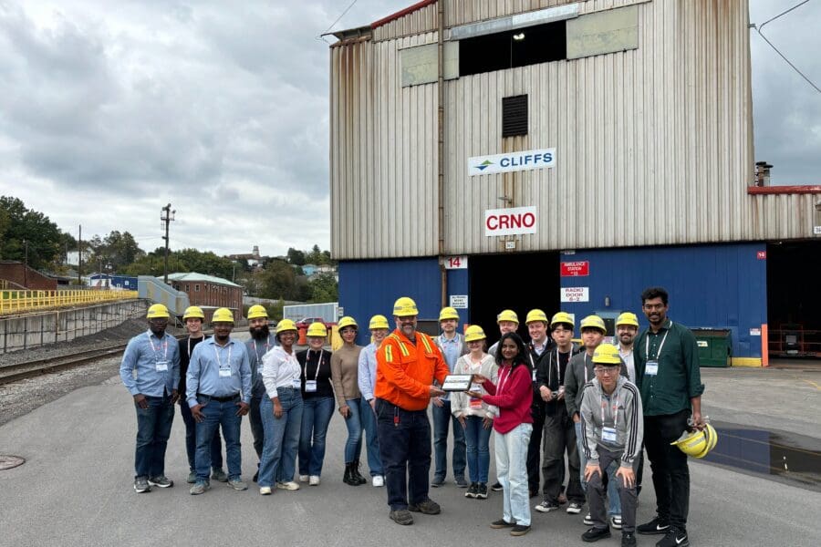 group standing outside a steel mill