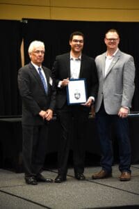 3 men posing with an award