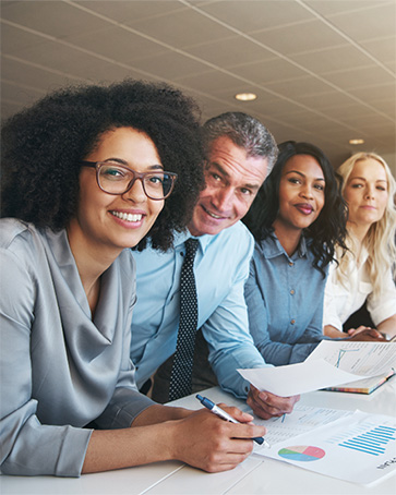 People in business attire work at a conference table