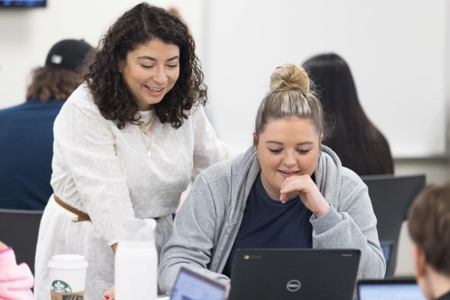 A professor works with a student in class