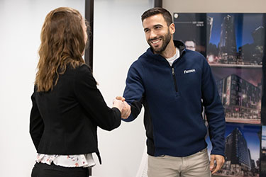 A COB student shakes hands with an employer during a mock interview.