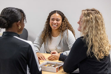 Three people sit together during an advising session.