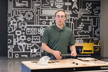 A student measures items that are sitting on a table