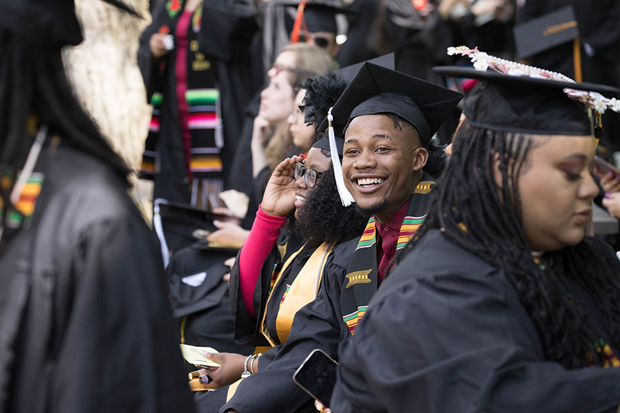 Students sit in commencement regalia during a ceremony