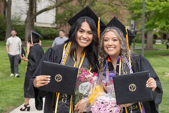 PNW graduates pose outdoors with their diplomas