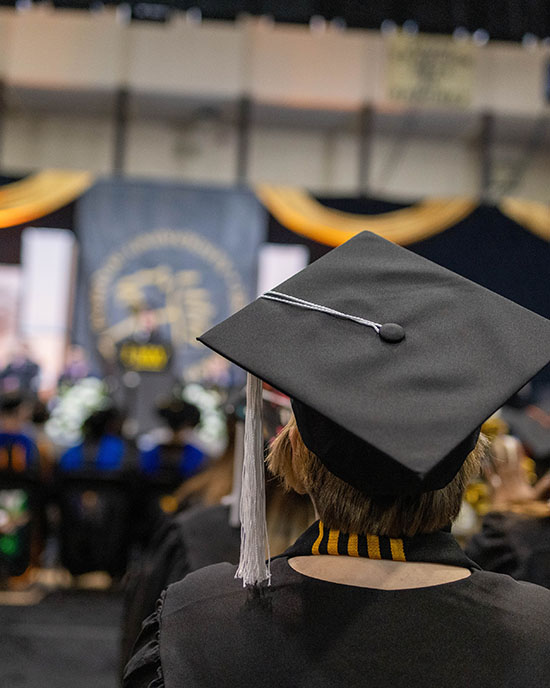 A PNW graduate in cap and gown at the commencement ceremony.