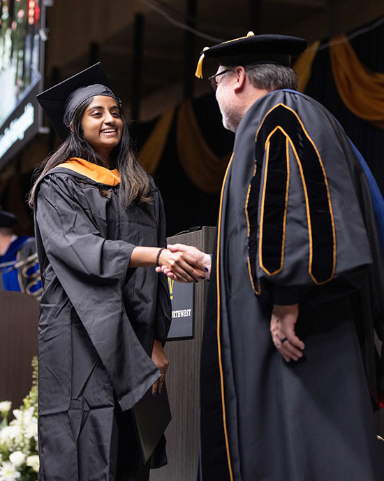 A Fall 2024 PNW graduate shakes hands with Chancellor Holford