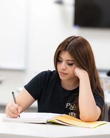 A student writes in a notebook