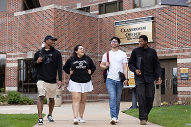 Four students walk together outdoors