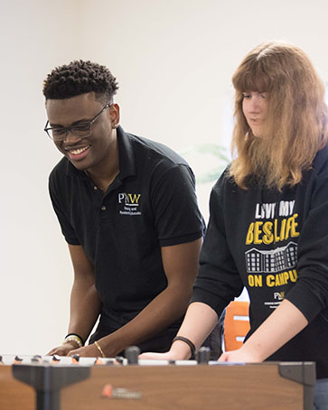 Two students play foosball in Housing