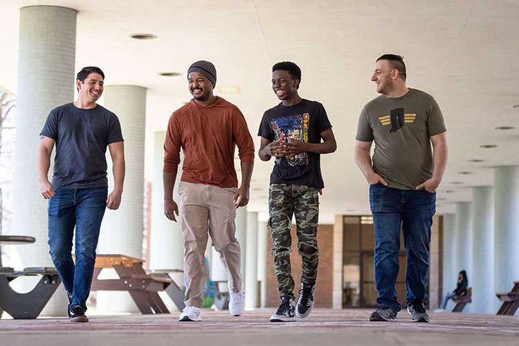 Four student veterans walk together outside