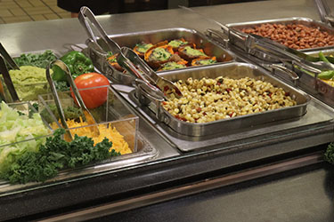 A buffet in dining services stocked with quinoa and veggies