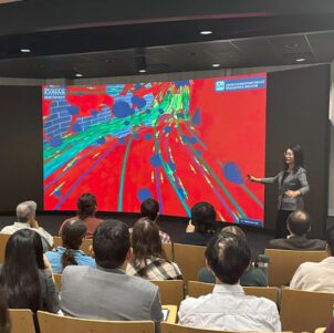 Chenn Zhou stands in front of an audience and gives a presentation