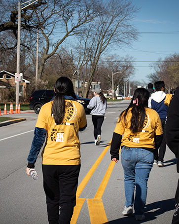 Two people walk in Honors College 5K shirts