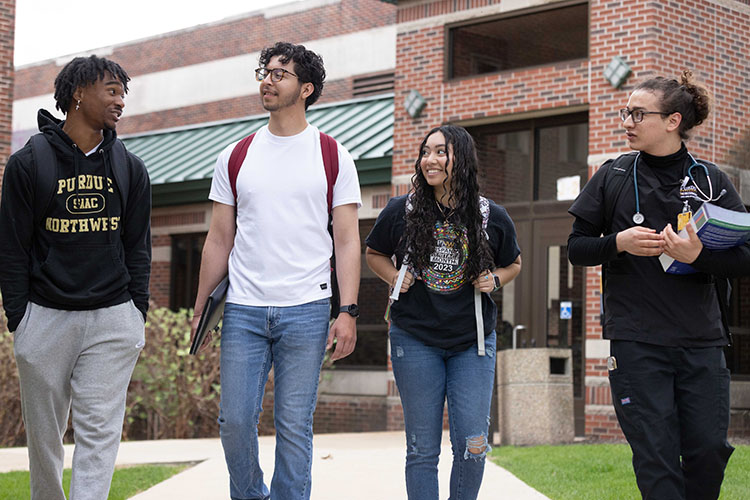 Four students walk outside on campus