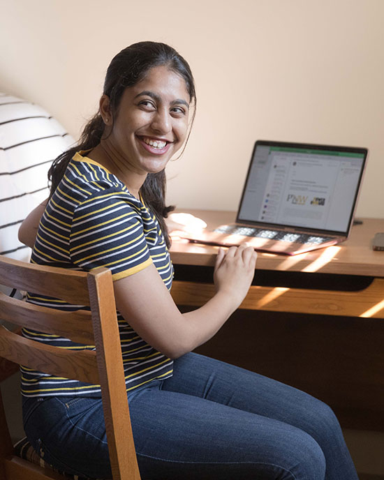 Student sitting at a desk with open laptop