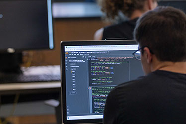 A PNW student works on a computer in a classroom