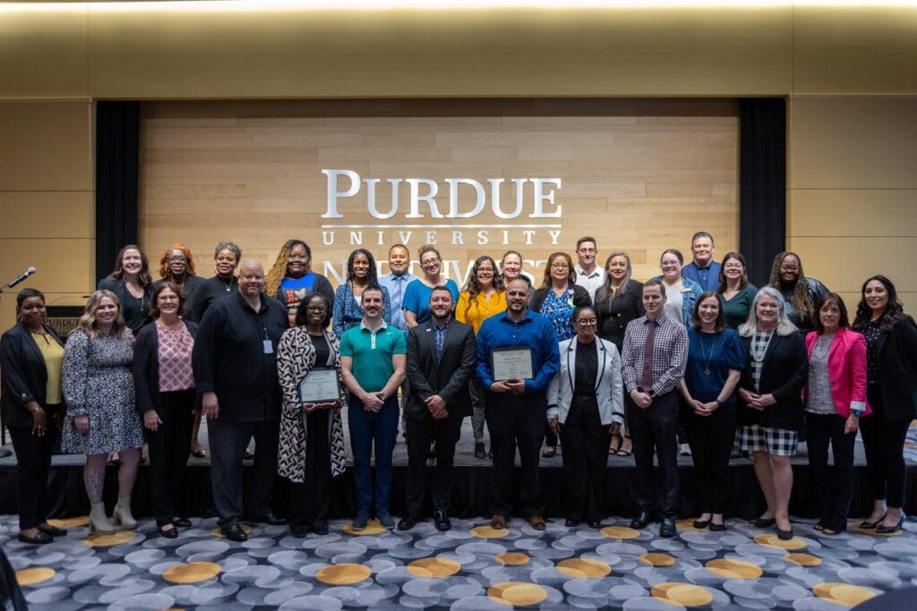 A group shot of participants in the 2023-2024 Leadership Northwest Indiana class standing in front of a Purdue University Northwest logo.