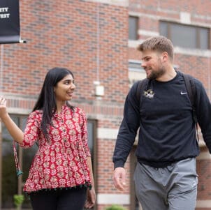 Two students walk together outside.