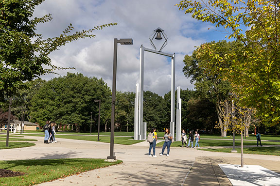 Students walk around the bell tower on the Hammond Campus
