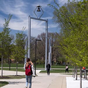 A PNW student walks in front of the Bell Tower