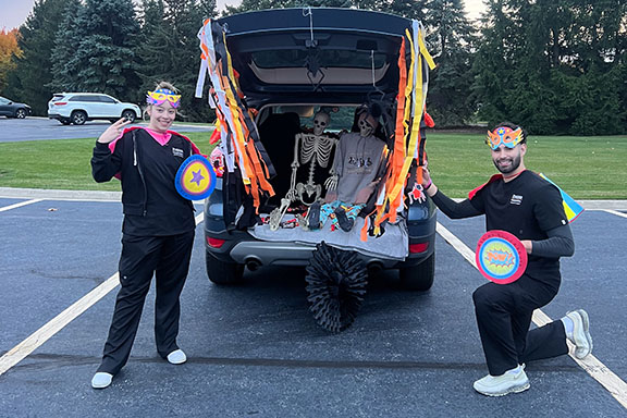 Two nursing students pose next to their car during a Trunk or Treat