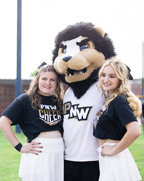 Two of PNW's cheerleaders pose with Leo the Lion.