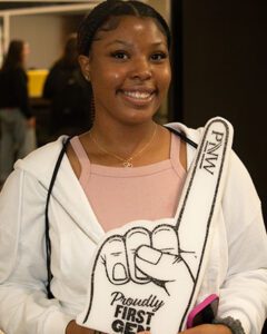 a student holds up a first gen foam finger