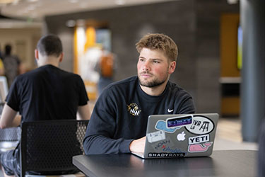 A PNW student works on his laptop