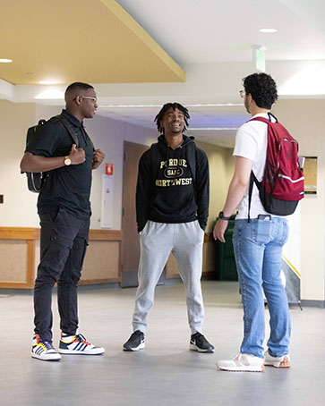 Three students stand together in CLO