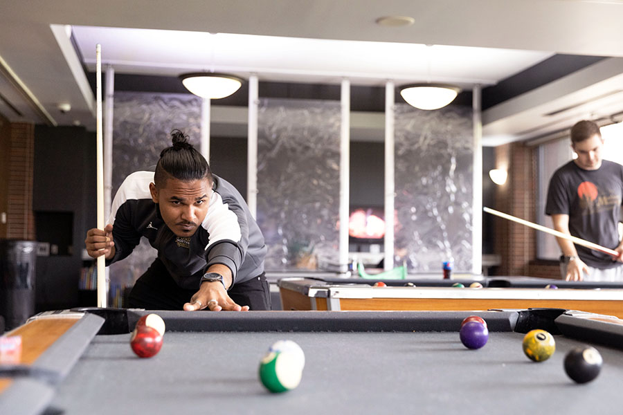 A PNW student lines up a pool shot.