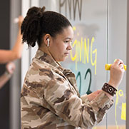 A student uses paint markers on a window.