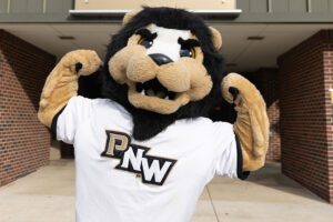 PNW mascot Leo flexes in front of the fitness building.