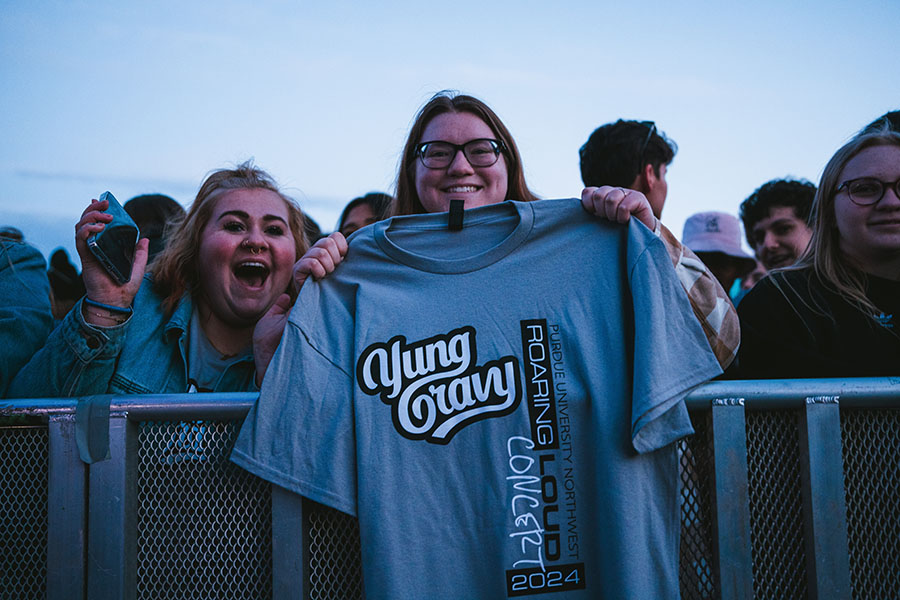 Two students hold up a Roaring Loud t-shirt.