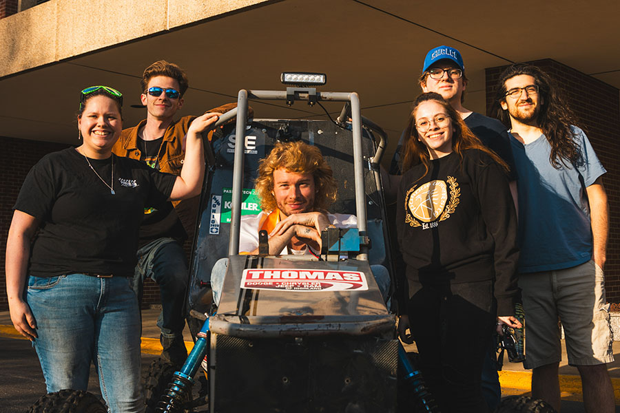 Members of the baja team pose with their buggy. Yung Gravy is sitting inside the buggie.