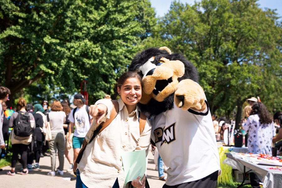 A PNW student poses with mascot Leo at a Welcome Rally