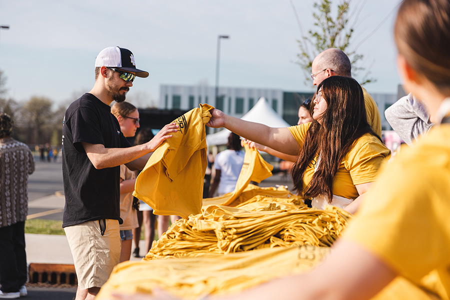 Roaring Loud 2023, passing out yellow t-shirts