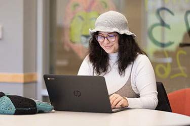 A PNW student works at a laptop