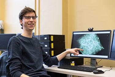 A PNW student shows off a computer simulation