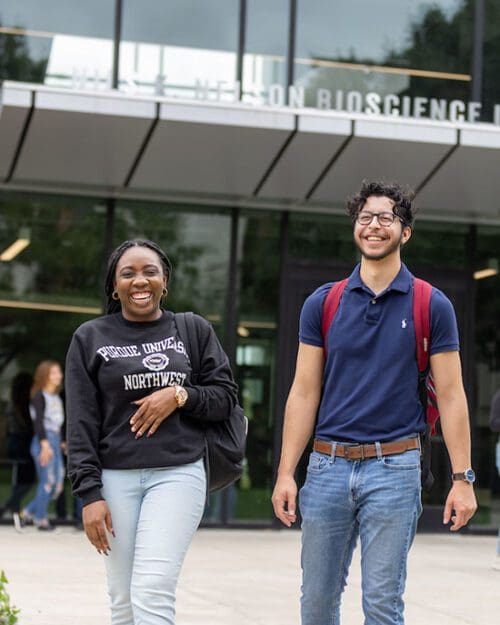 Two students walking together outside of the Nils Building