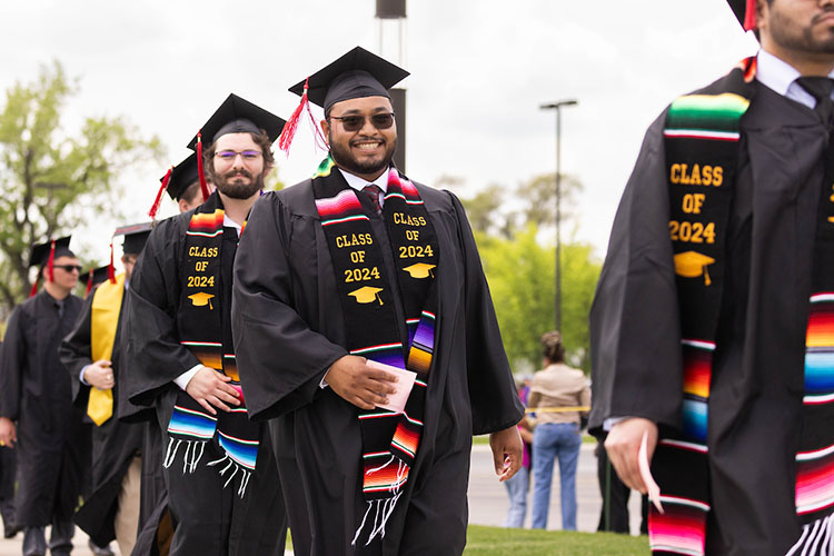 PNW students walk into a commencement ceremony.