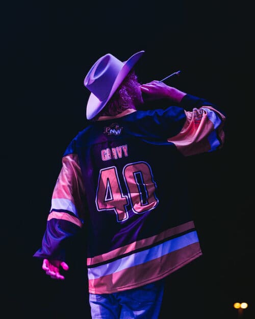 Yung Gravy performs onstage while wearing a PNW Hockey jersey.