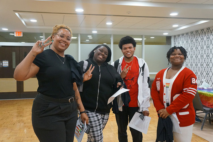 Four students pose together. They are all smiling