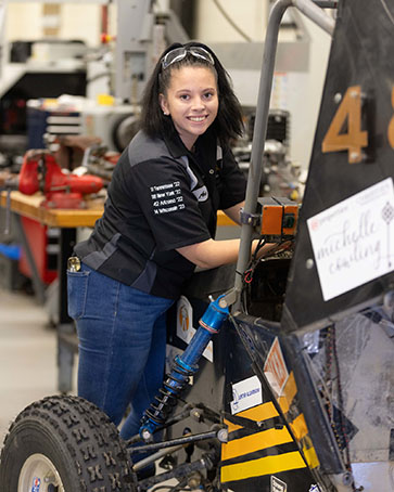 A PNW student works on a car competition