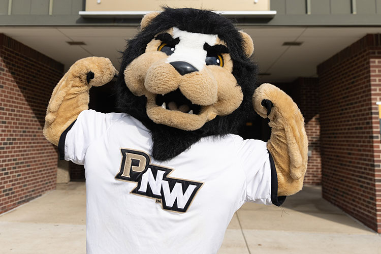 PNW mascot Leo the Lion flexes in front of the Fitness & Recreation Center